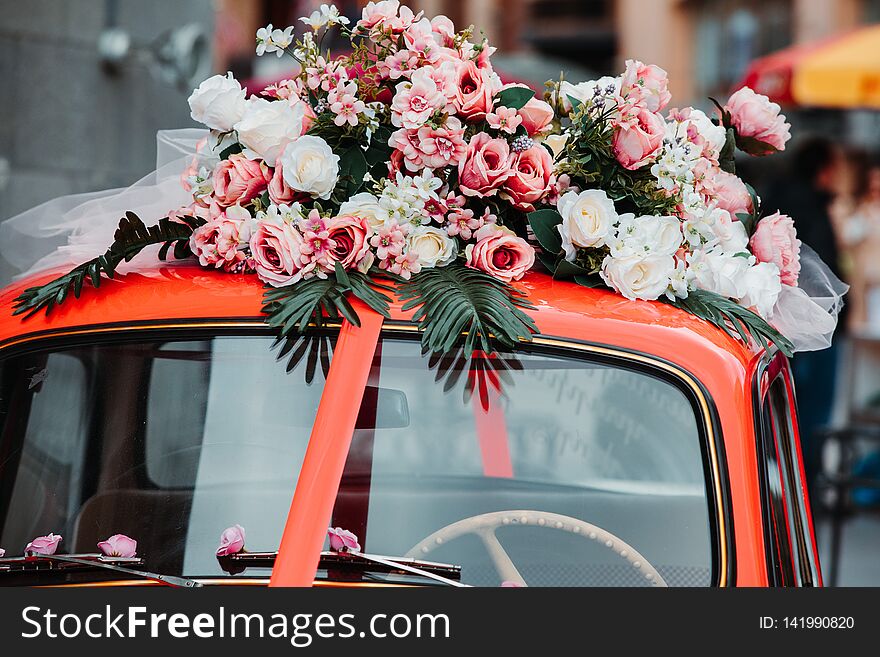 Old red car with red ribbon and flowers on top. Old red car with red ribbon and flowers on top