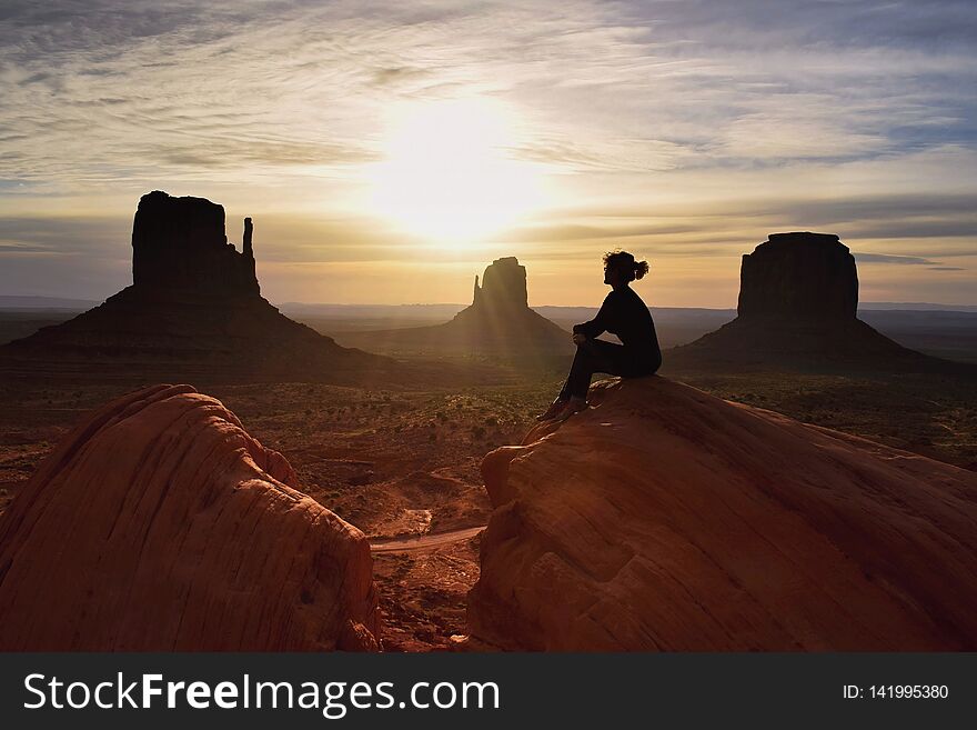 Woman hiker watching beautiful scenery of sunrise in Monument valley, Navajo tribal park , Utah, USA. Woman hiker watching beautiful scenery of sunrise in Monument valley, Navajo tribal park , Utah, USA