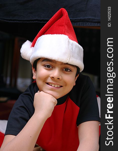 Portrait of a smiling 8 year old boy in a Santa hat. Portrait of a smiling 8 year old boy in a Santa hat