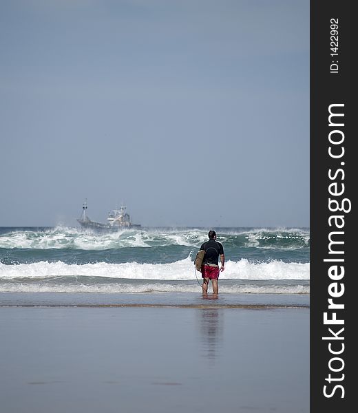 A Young Man Stands On The Coastline Checking Surf Conditions