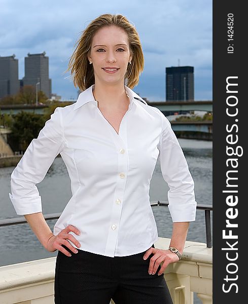 A young successful businesswomen standing confidently in front of city. A young successful businesswomen standing confidently in front of city.