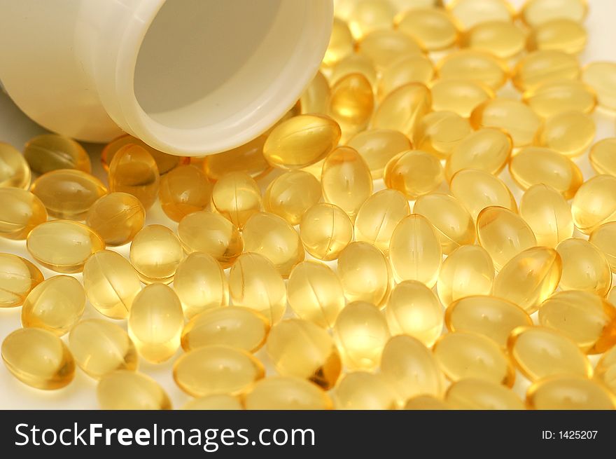 Yellow transparent shiny tablets and a bottle. Yellow transparent shiny tablets and a bottle.