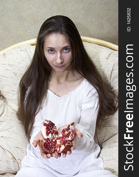 Woman sitting in an armchair with fruit in hands. Woman sitting in an armchair with fruit in hands