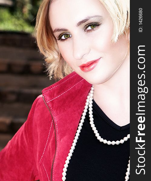 Blond business-woman with short hair in red leather jacket and pearls. Blond business-woman with short hair in red leather jacket and pearls