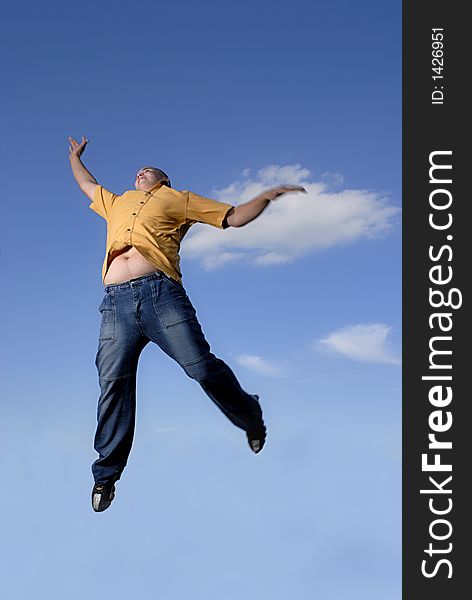 Young boy happily jumping against blue sky. Young boy happily jumping against blue sky.