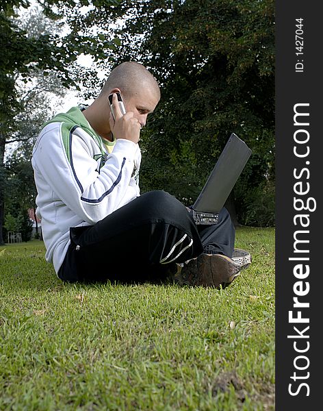 Pictyre of boy with notebook and cell phone in park