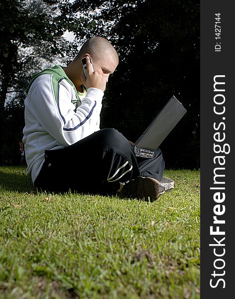 Pictyre of boy with notebook and cell phone in park