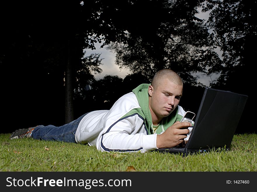 Boy With Notebook And Cell Phone In Park