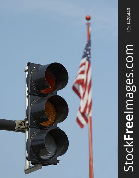 Trafic light and USA flag before blue sky