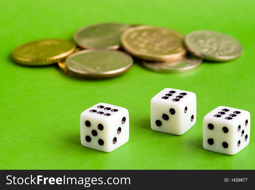 Dices and coins on a green background