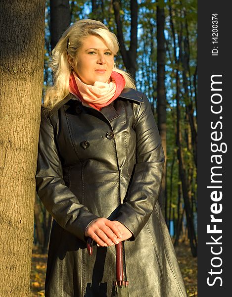 Woman in a leather coat walks in autumn park. Woman in a leather coat walks in autumn park