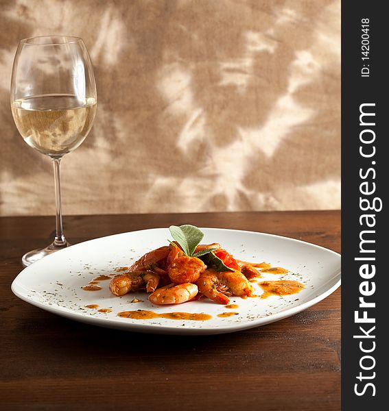 Photo of delicious prawns with tomato and sage putted on a wood table