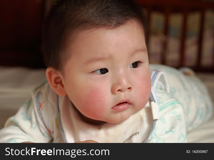 Lovely Chinese baby is playing in the bed