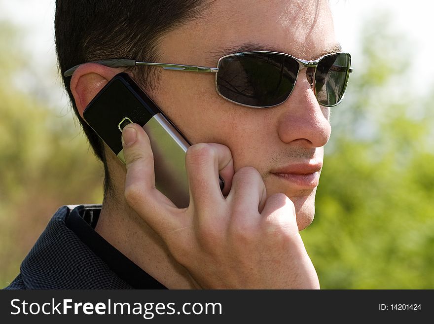 Young Man In Sunglasses Talks On The Phone