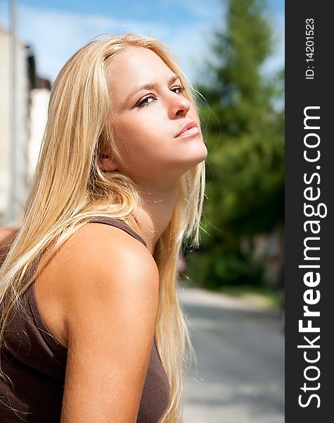 Beautiful  lovely woman posing outside against blue sky