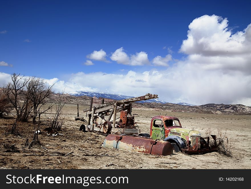 Old truck in the desert with blue sky and clouds in the background. Old truck in the desert with blue sky and clouds in the background
