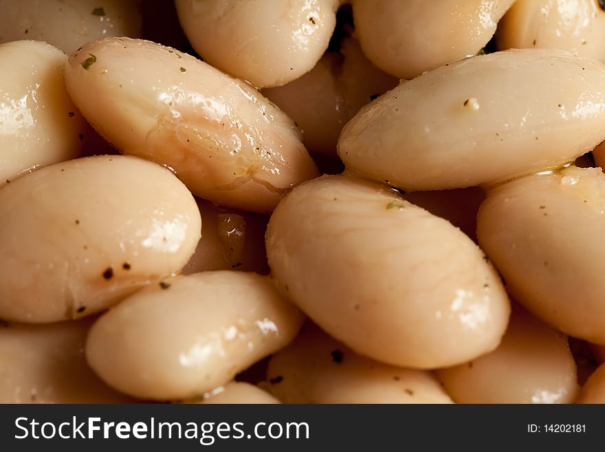 Photo of spanish beans on a white plate with a basil leaf