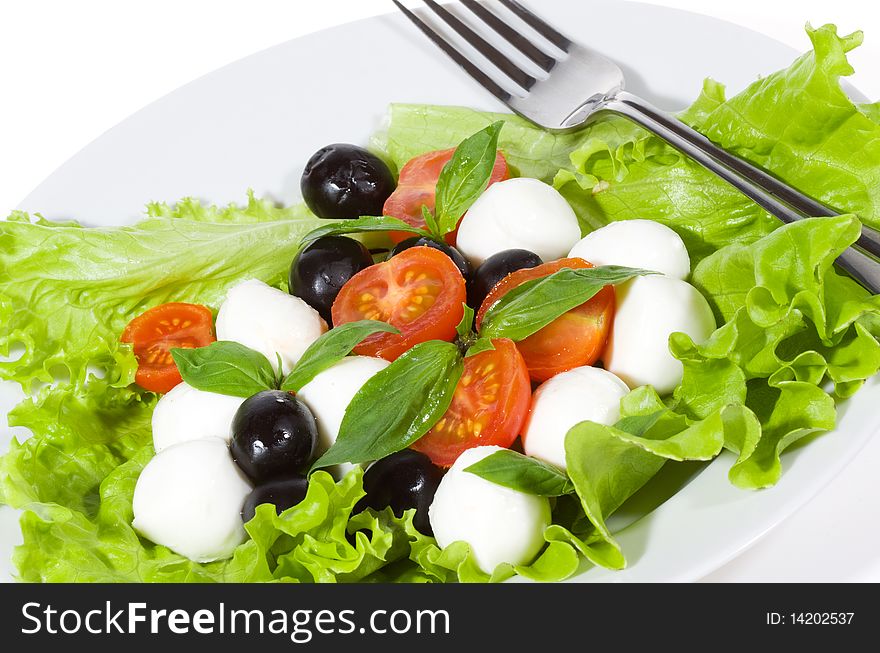 Salad with mozzarella, olives, basil and tomatoes