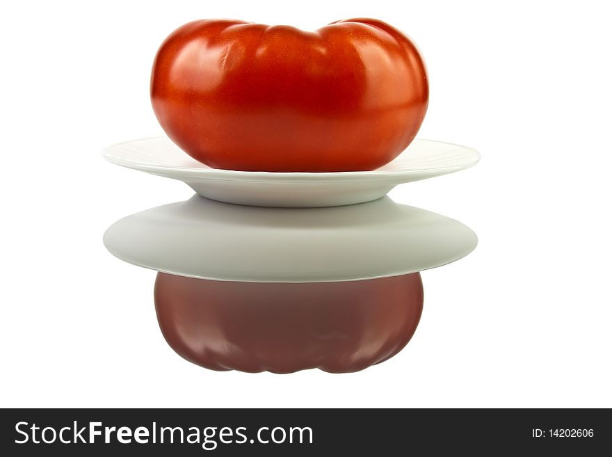 Large red ripe juicy tomato on a plate