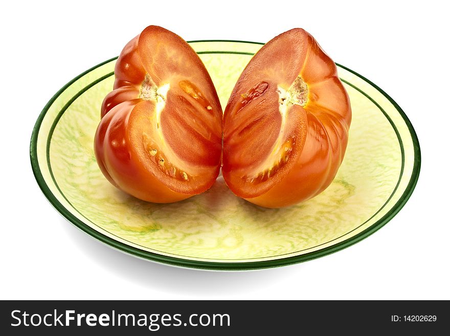 Tomato, cut in half on the green plate. Tomato, cut in half on the green plate