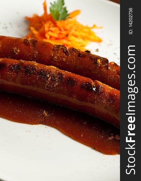 Photo of German Sausagen on a plate with carrots and curry ketchup