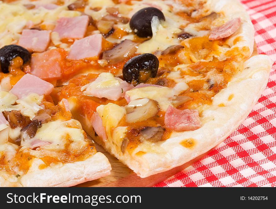 Pizza with ham and vegetables as background