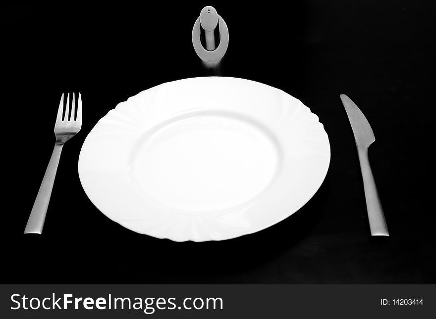Silverware and plate isolated on black. Silverware and plate isolated on black