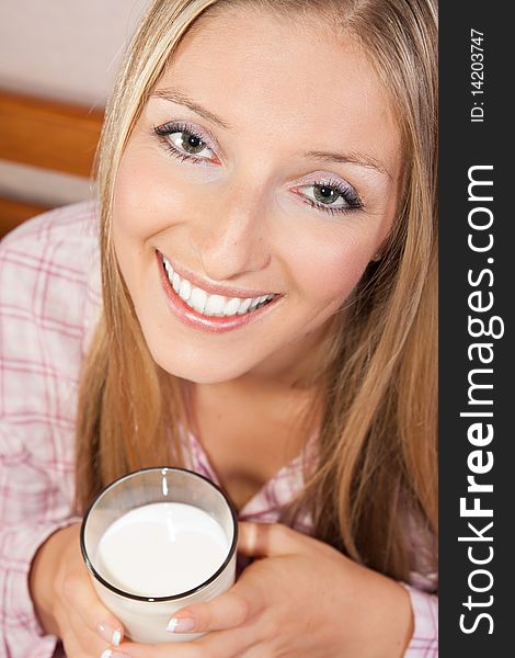 Woman in bed with glass of milk