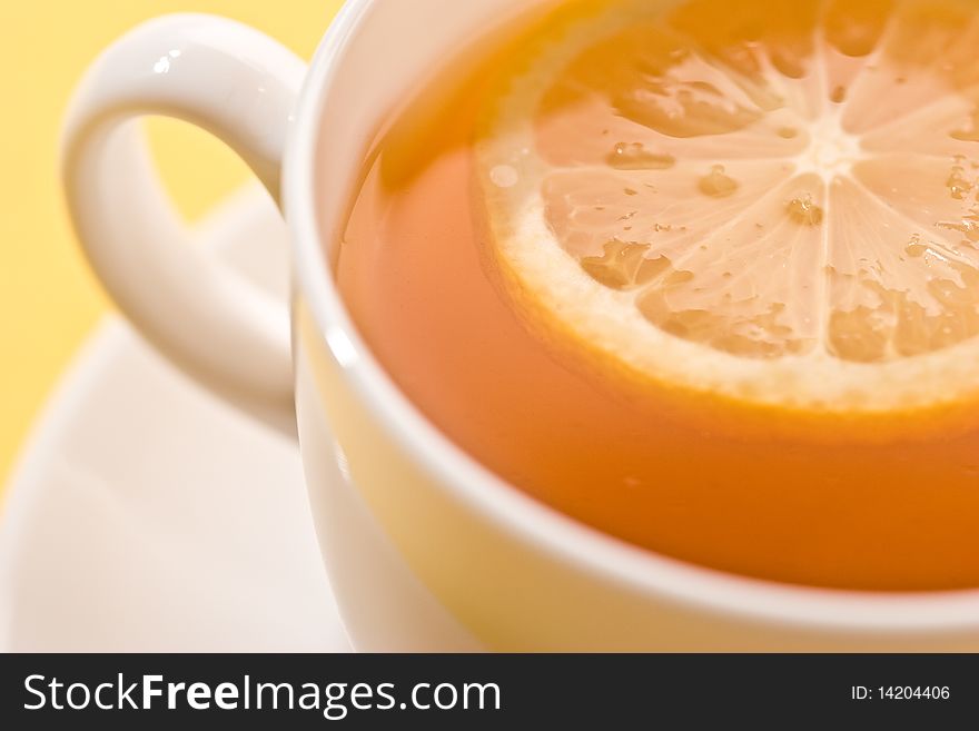 Cup of tea with lemon over yellow. Cup of tea with lemon over yellow