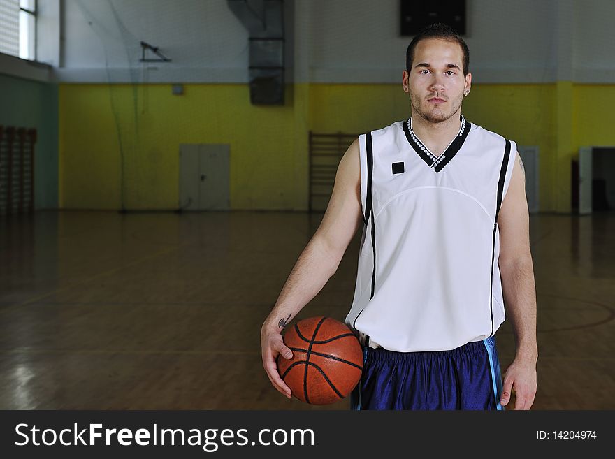 One healthy young man play basketball game in school gym indoor relax. One healthy young man play basketball game in school gym indoor relax