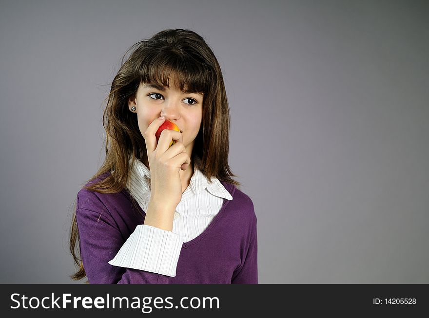 Beautiful teen trying to eat one apple. Beautiful teen trying to eat one apple