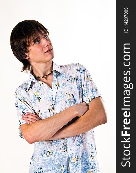 A young male model on a white background wearing a shirt with short sleeves. With the hands combined on a breast. A young male model on a white background wearing a shirt with short sleeves. With the hands combined on a breast.