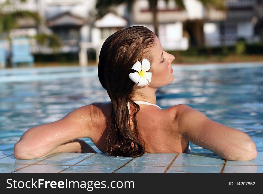 Young beautiful woman with flower in swimming pool. Young beautiful woman with flower in swimming pool