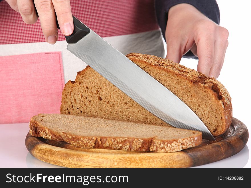 Details cutting bread with knife in closeup
