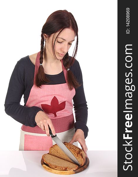 Beautiful housewife cutting bread with knife on white background