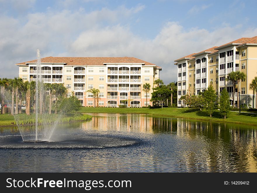 Waterfront condo living in tropical setting with palm trees, fountain and water. Waterfront condo living in tropical setting with palm trees, fountain and water