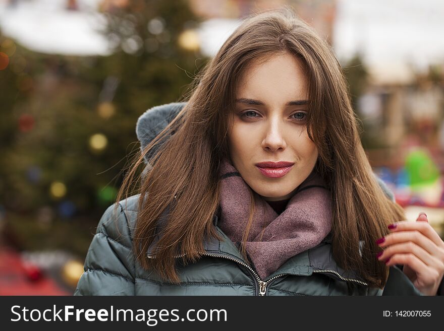 Closeup portrait of a young woman in the winter down jacket