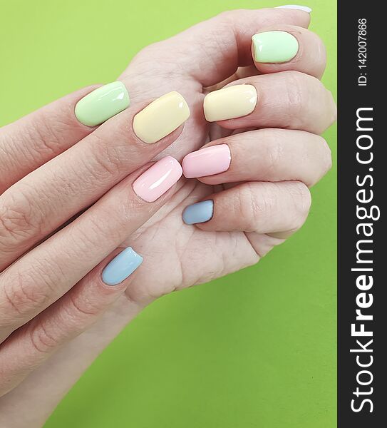 Female hands manicure on color paper minimal