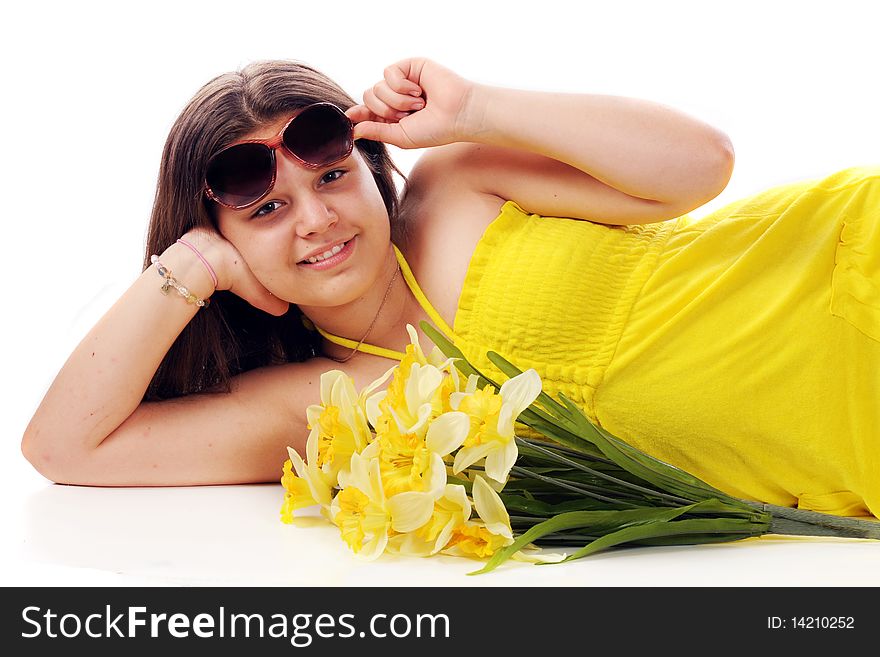 A young teen reclining with cut daffodils peeking out from under her sunglasses. Isolated on white. A young teen reclining with cut daffodils peeking out from under her sunglasses. Isolated on white.