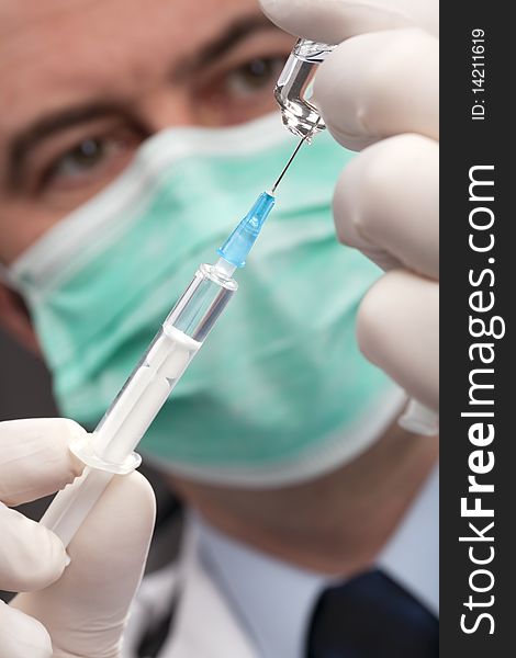 Professional doctor with medical syringe in hands, getting ready for injection