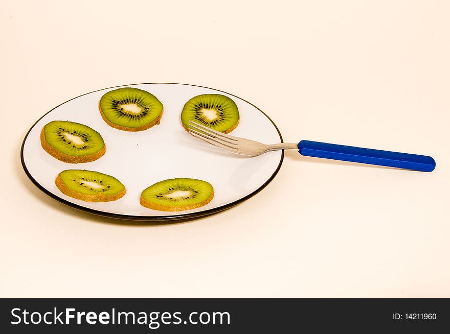 Kiwi Slices On A Plate.