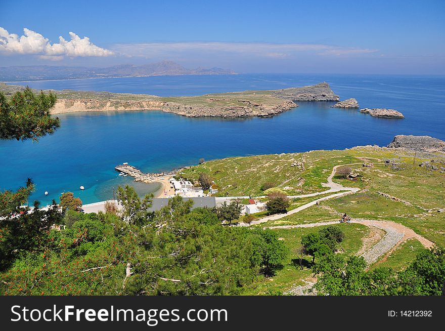 One of the most beautiful places of Rhodes. The beautiful sandy beach, crystal clear sea, blue sky, mountains. One of the most beautiful places of Rhodes. The beautiful sandy beach, crystal clear sea, blue sky, mountains.