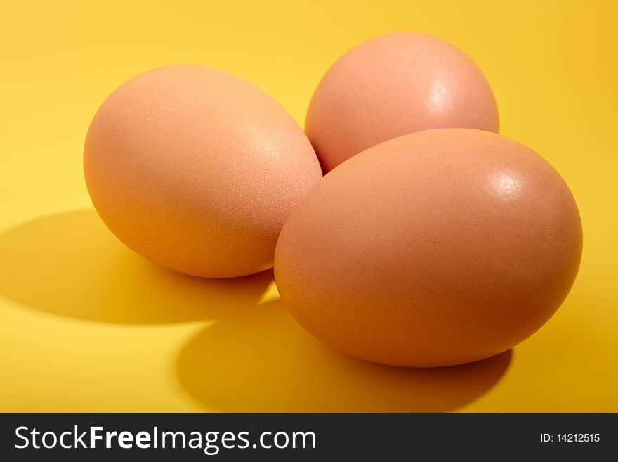 Three eggs on yellow background