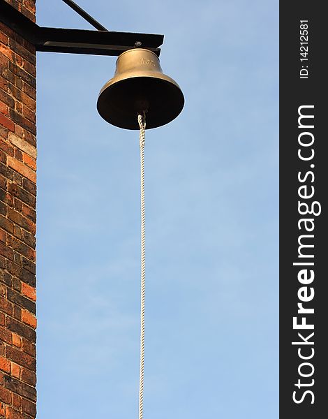 Bell with rope on the corner of the building