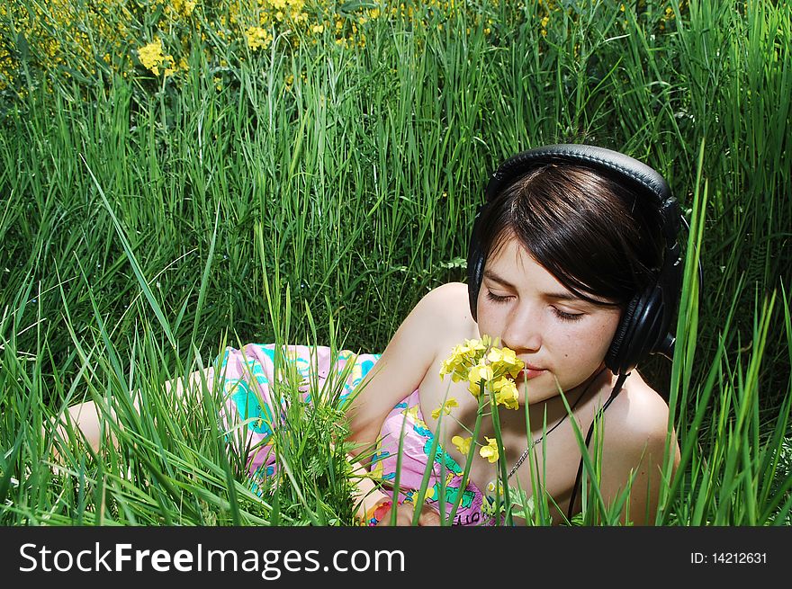 A beautiful young girl listening music in nature. A beautiful young girl listening music in nature