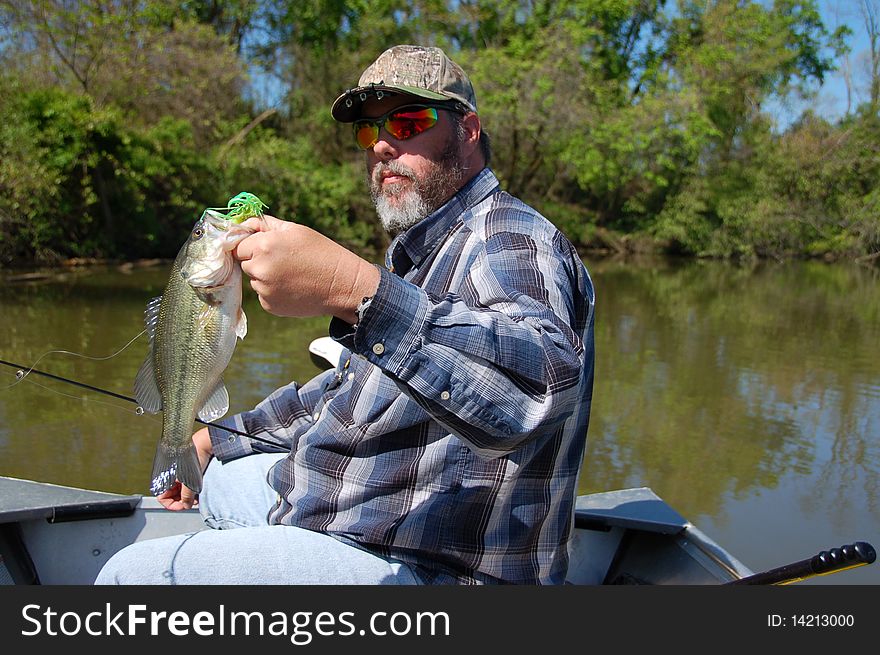 Fisherman holding a large mouth bass closeup. Fisherman holding a large mouth bass closeup