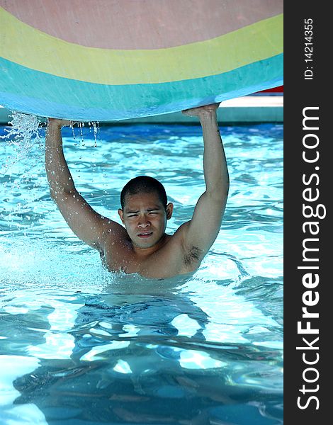 Handsome young asian man relaxing at the pool. Handsome young asian man relaxing at the pool