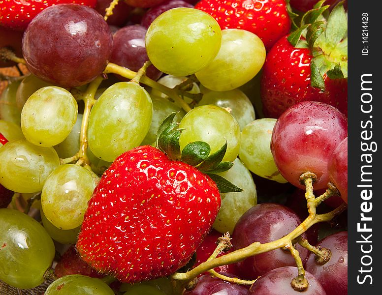 Fresh strawberries and grapes closeup composition