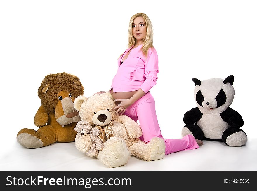 Pregnant girl in pink sports suit with toys on white back