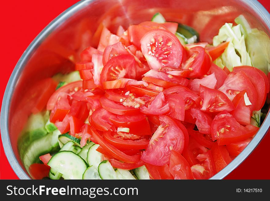 Cucumbers and tomatos salad in the metall plate